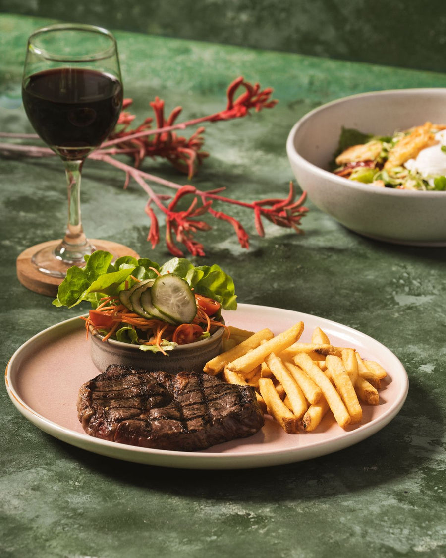 Grilled steak with chips and garden salad and a glass of red wine