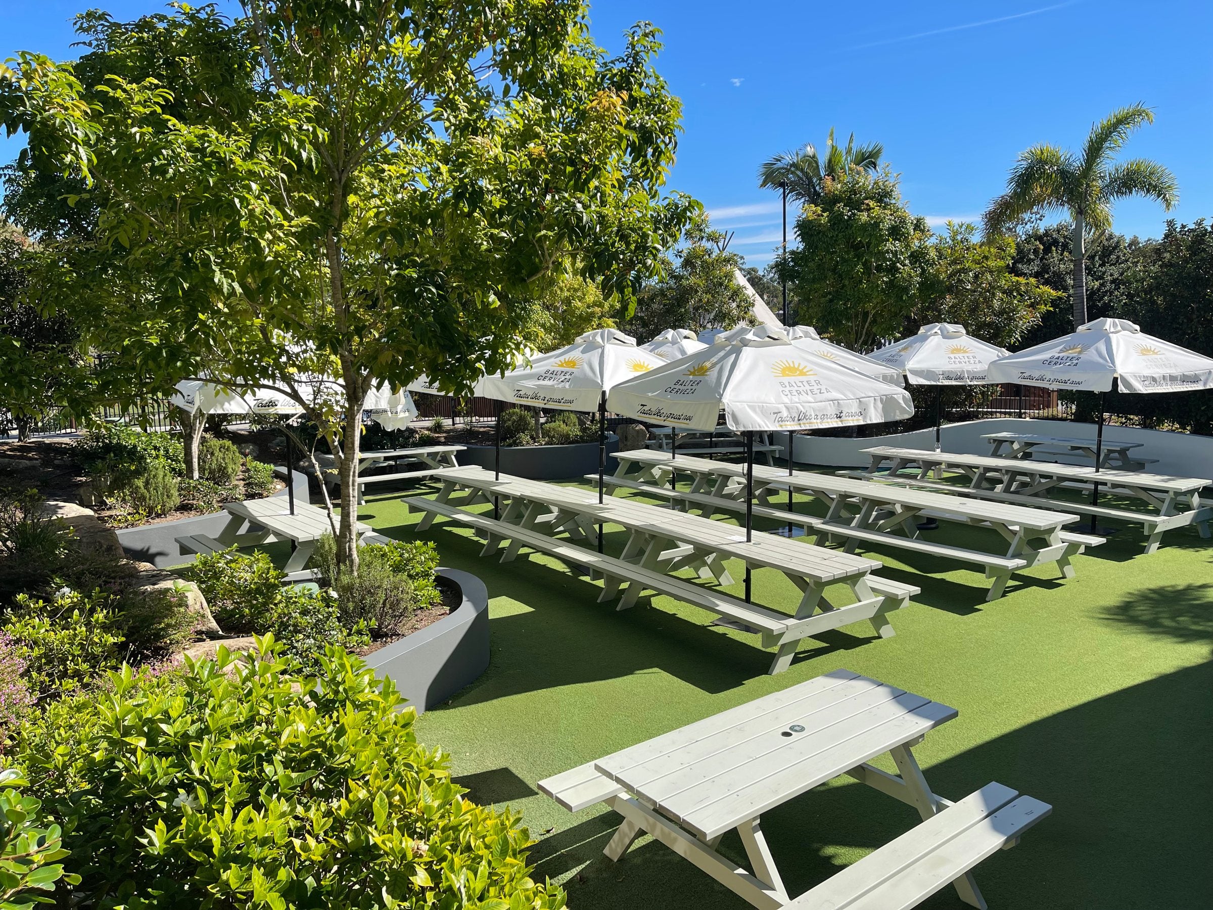 Picnic tables and umbrellas on the Backyard lawn at Parkwood Village